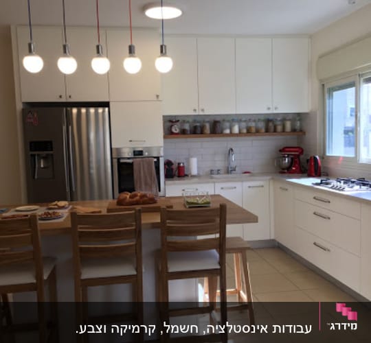 מטבח מודרני עם ארונות לבנים ותאורה תלויה
